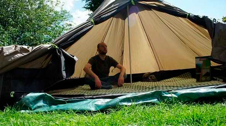 Man sitting on a tarp in a tent