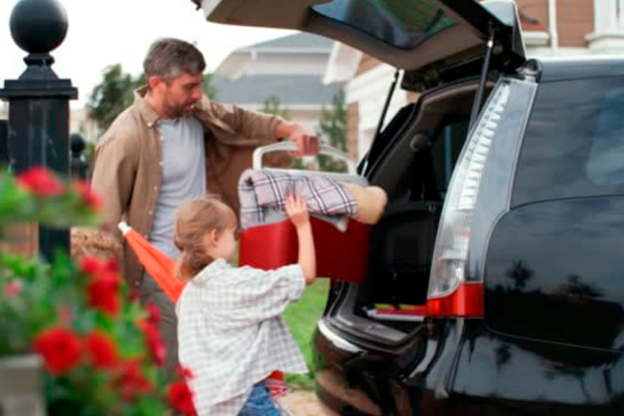 A Man packs his car with his daughter